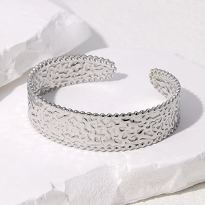 Bracciale vintage argento con trama irregolare e bordo perlato su supporto in pietra