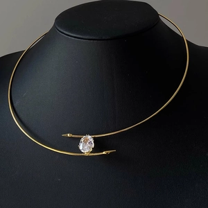 Collier ras du cou doré avec zircon ovale sur un buste de mannequin noir mat
