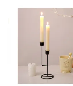 Detail of minimalist black iron dual-head candle holder with textured matte finish