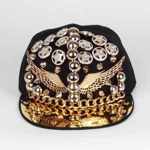 Détail de casquette punk hip hop avec ailes dorées, rivets et visière miroir dorée
