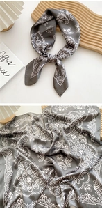 Detail of grey paisley silk square scarf showing intricate pattern and smooth texture