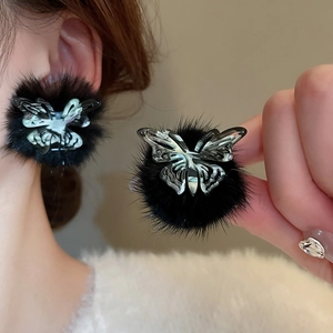 Detail view of black flocked heart earrings featuring a silver镂空butterfly decoration