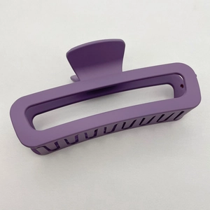 Close-up of a matte purple rectangular hair claw clip with a smooth rubberized finish