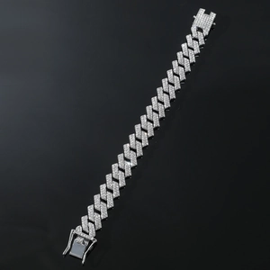Macro shot of silver iced out Cuban link bracelet with sparkling stones on dark background