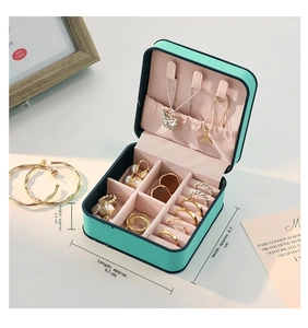 Mini portable jewelry box detail showing compact mint green case and velvet interior slots