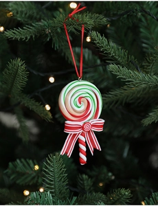 Close-up of red and white candy cane ornament with a striped bow on a festive tree