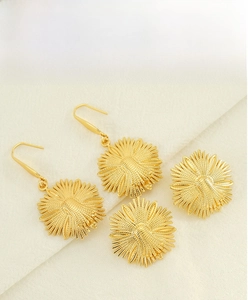 Detailed macro view of golden sunflower earrings with textured petals on linen background