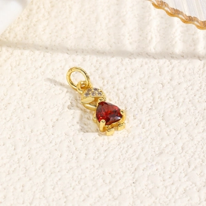 Macro shot of 18k gold plated turtle pendant with red heart stone and zircon head detail