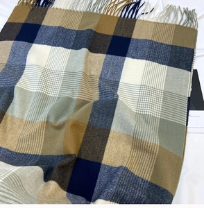 Detailed texture of navy and beige plaid scarf with soft cashmere-like tassels