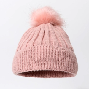 Pink rib-knit beanie with a large faux fur pompom and folded cuff for winter warmth