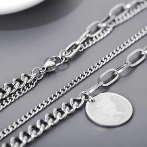 Detailed macro view of silver layered steel chains and Elizabeth II coin pendant