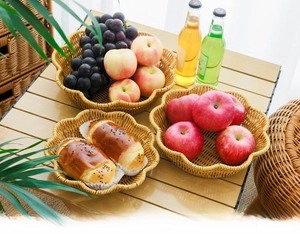 Detail of hand-woven fruit basket with petal edge design and natural PE rattan texture