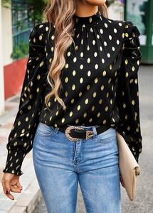 Detail of puff sleeves and gold polka dot pattern on black long sleeve crew neck shirt