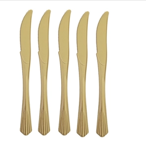 Detail view of five gold plastic knives with serrated edges for party tableware