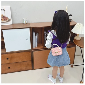 Pink jelly cross-body bag for girls featuring pearl handle and cartoon charms detail