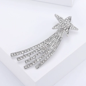 Macro shot of silver shooting star brooch with sparkling rhinestones and tassel detail