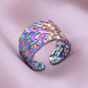 Macro detail of iridescent wide open ring featuring a unique hammered rock texture