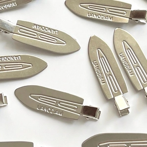 Silver matte metal seamless hair clips with UANODIAM engraved logo on white background