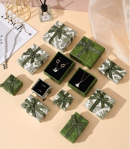 Detail of luxury emerald green jewelry boxes with Best Wishes ribbons and pearl decor