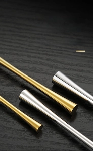 Detail showing high-polish gold and silver thick handles on dark wood texture