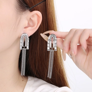 Détail de boucles d'oreilles longues à pampilles argentées avec arche en strass