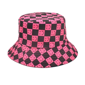 Detailed close-up of pink and black checkerboard bucket hat with smiling face patterns