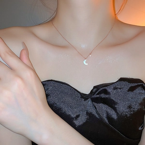 Détail du collier ras du cou lune et étoile or rose avec nacre sur le cou
