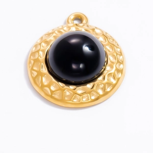 Detail of 18k gold vintage circular pendant featuring a polished black obsidian stone