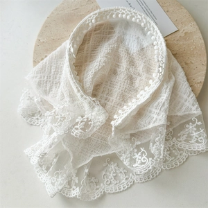 Detailed close-up of a white floral lace headband on a marble tray with delicate crochet edges