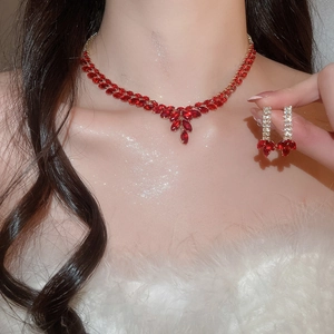 Macro detail of royal style tassel necklace and earrings set with red crystals