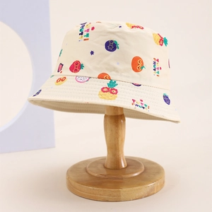 Detail of kids sun hat with colorful fruit print and Tutti Fruitti text on cotton fabric