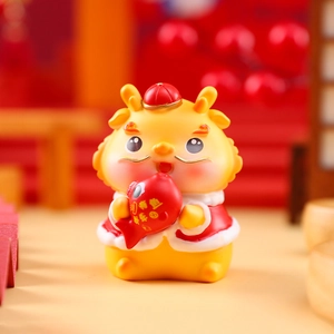 Close-up of yellow Chinese zodiac dragon figurine holding a red carp with auspicious text