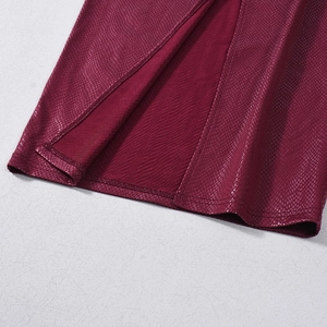 Detail of red snake-skin textured faux leather dress featuring a side slit hem