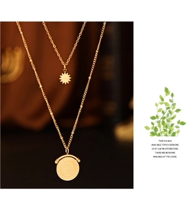 Detail view of double-layered gold necklace with sun star and embossed coin charms