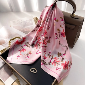 Elegante pañuelo de seda rosa con estampado floral de magnolia sobre un bolso de moda