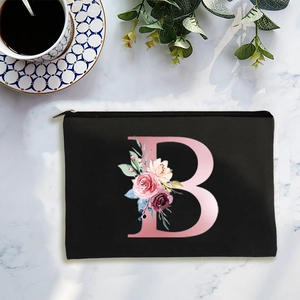 Minimalist black canvas cosmetic bag with floral letter B on marble background