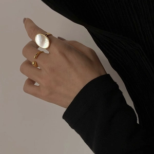 Detail of gold minimalist open rings featuring a large oval white mother of pearl inlay