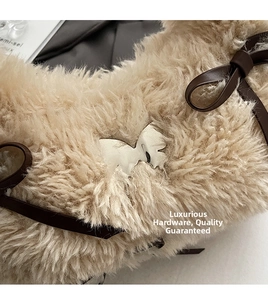 Close-up of plush faux fur bag with silver animal-shaped metal buckle and brown leather bow