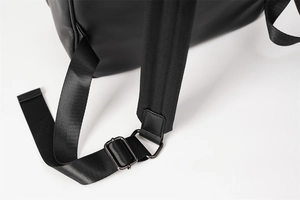 Detail shot of the adjustable buckle and fine leather stitching on black woven backpack