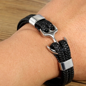 Close-up of black braided leather bracelet with silver anchor clasp on wrist