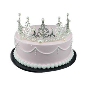 Silver crown cake topper with pearls and rhinestones on a pink princess cake