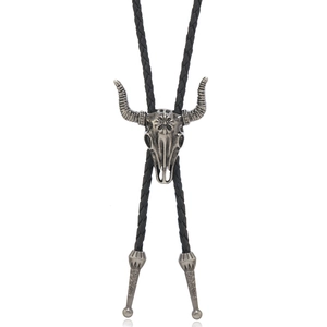 Detail of silver bull skull bolo tie with black braided leather cord and engraved tips