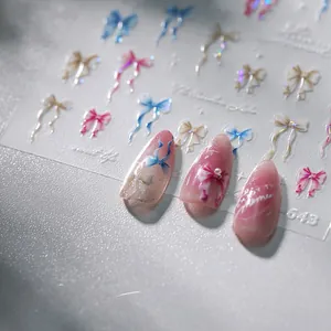 Macro shot of 3D iridescent bow nail stickers with pink gradient nails and pearl accents