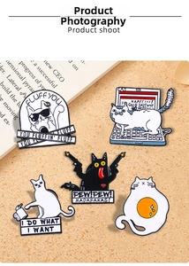 Detailed macro view of cute cartoon cat enamel pins on an open vintage book page