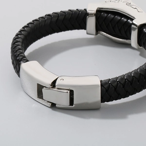 Macro view of woven black leather bracelet with polished silver metal lion head clasp