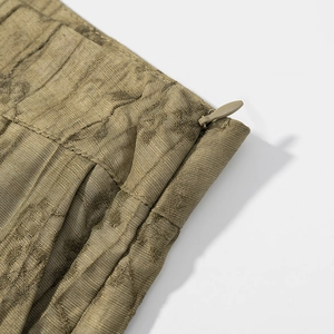 Detail of olive gold jacquard fabric with invisible zipper and elegant pleated design