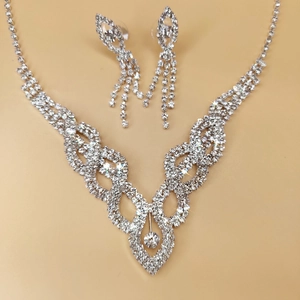 Detail view of silver bridal jewelry set featuring hollow crystal necklace and earrings