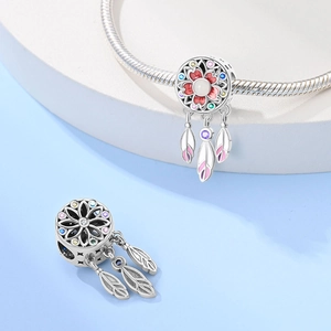 Macro shot of silver dreamcatcher charm with colorful gemstones and pink gradient feathers