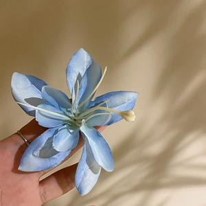 Close-up of light blue fabric hibiscus flower hair clip with realistic stamens