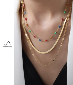 Vue détaillée du collier triple rang en acier inoxydable doré avec perles multicolores
